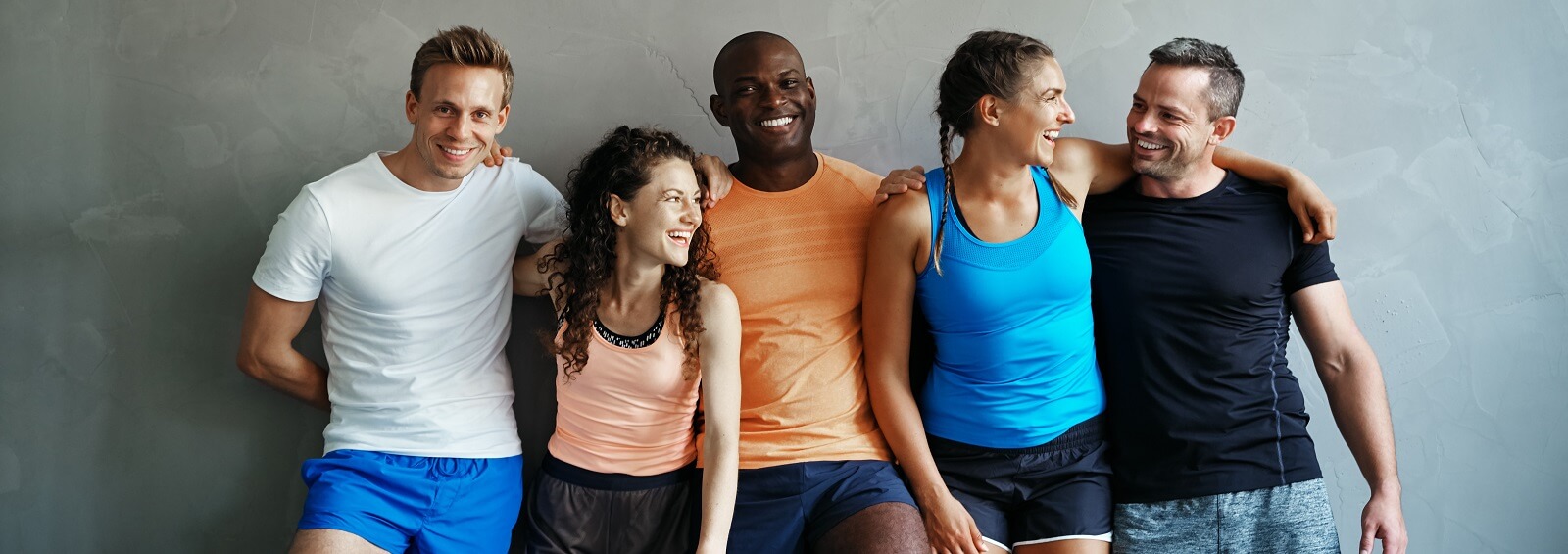 Diverse Group Of Laughing Friends Standing Together At The Gym